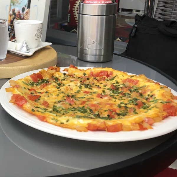 A vegetable omelet on a plate at an outdoor cafe table